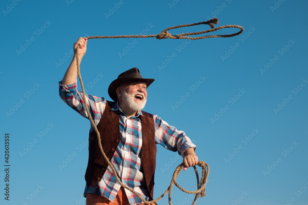Old wild west cowboy with rope. Bearded western man throwing lasso