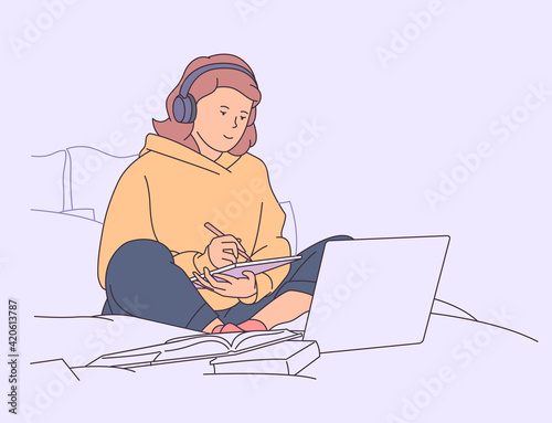 Education, study, learning concept. Girl studying in bed with laptop and books.