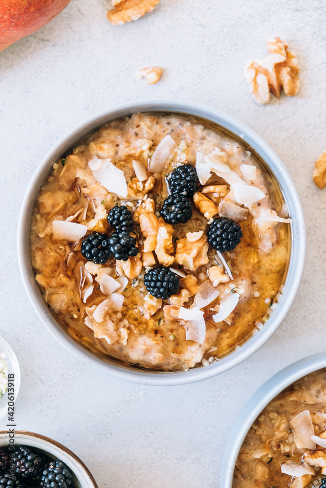 Homemade porridge topped with wild blackberries, walnuts and shr
