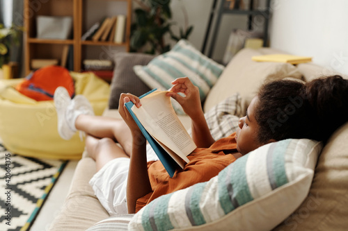 Girl Reading Book At Home