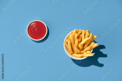 French fries with ketchup on blue background. photo