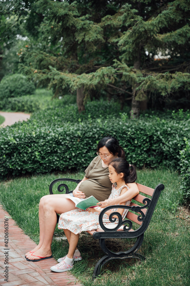 Pregnant woman with daughter in the park Pregnant woman with daughter in the park