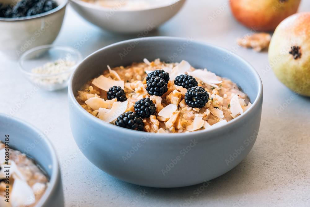 Homemade porridge topped with wild blackberries, walnuts and shr Homemade porridge topped with wild blackberries, walnuts and shr