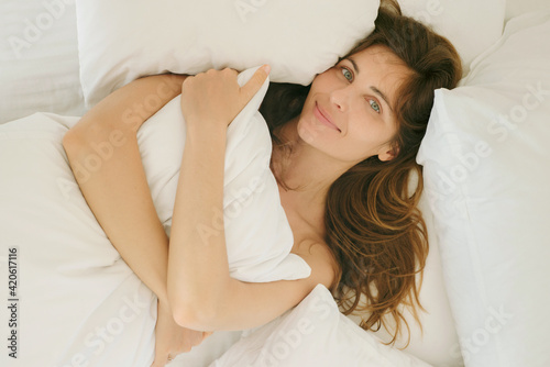 Beautiful girl lying in white bed