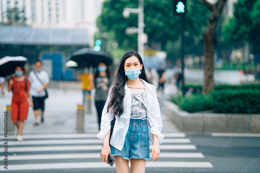 Young Asian women wearing mask walking on city street Young Asian women wearing mask walking on city street