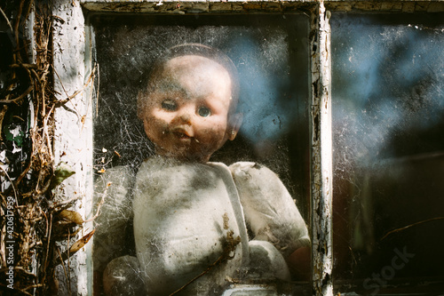 Slightly creepy baby doll at a window photo
