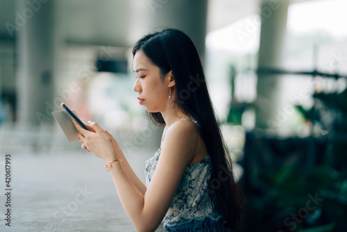 Young Asian women using mobile phones on the street in the city