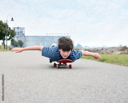 Boy Riding Skateboard Outside on Road