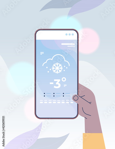 human hand holding smartphone with daily temperature mobile app weather forecasting and meteorology concept