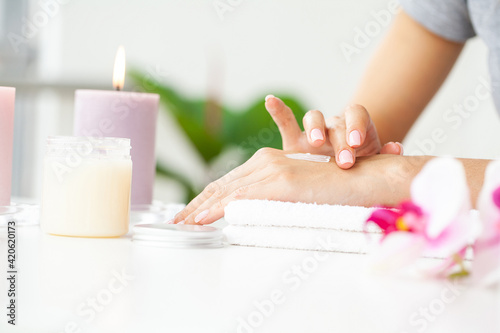 Woman applying hand cream at home, closeup