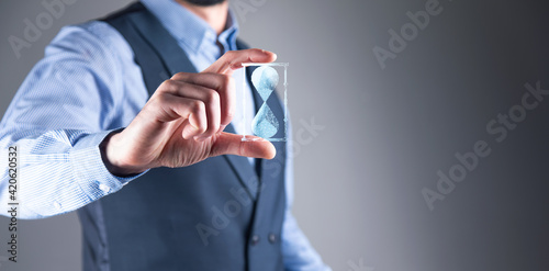 man holds in hand hourglasses icon