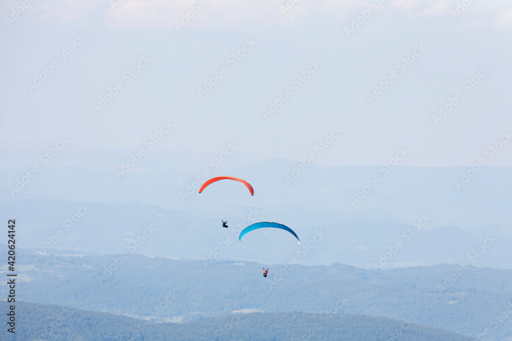 Two paragliders in the air over mountains Two paragliders in the air over mountains