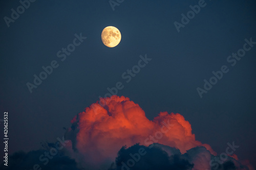 98% full moon with red clouds