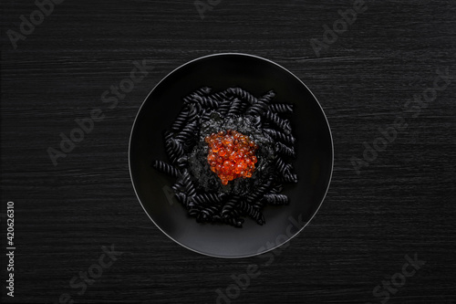 Black pasta with salmon caviar photo