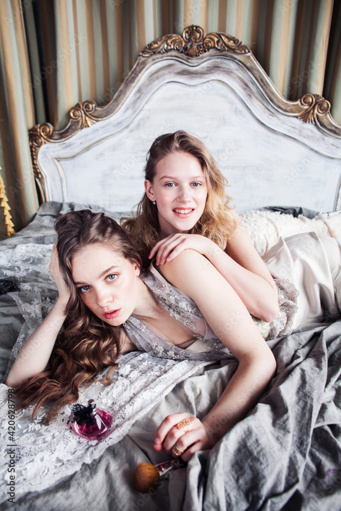 two pretty twin sister blond curly hairstyle girl in luxury house interior together, rich young people concept two pretty twin sister blond curly hairstyle girl in luxury house interior together, rich young people concept