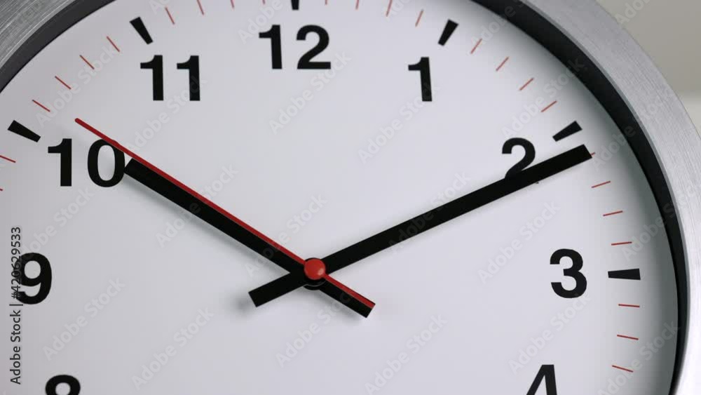 Large white wall clock Set the time for 10.10 o'clock. The red minute hand keeps running. Time lapse movie. Large white wall clock Set the time for 10.10 o'clock. The red minute hand keeps running. Time lapse movie.