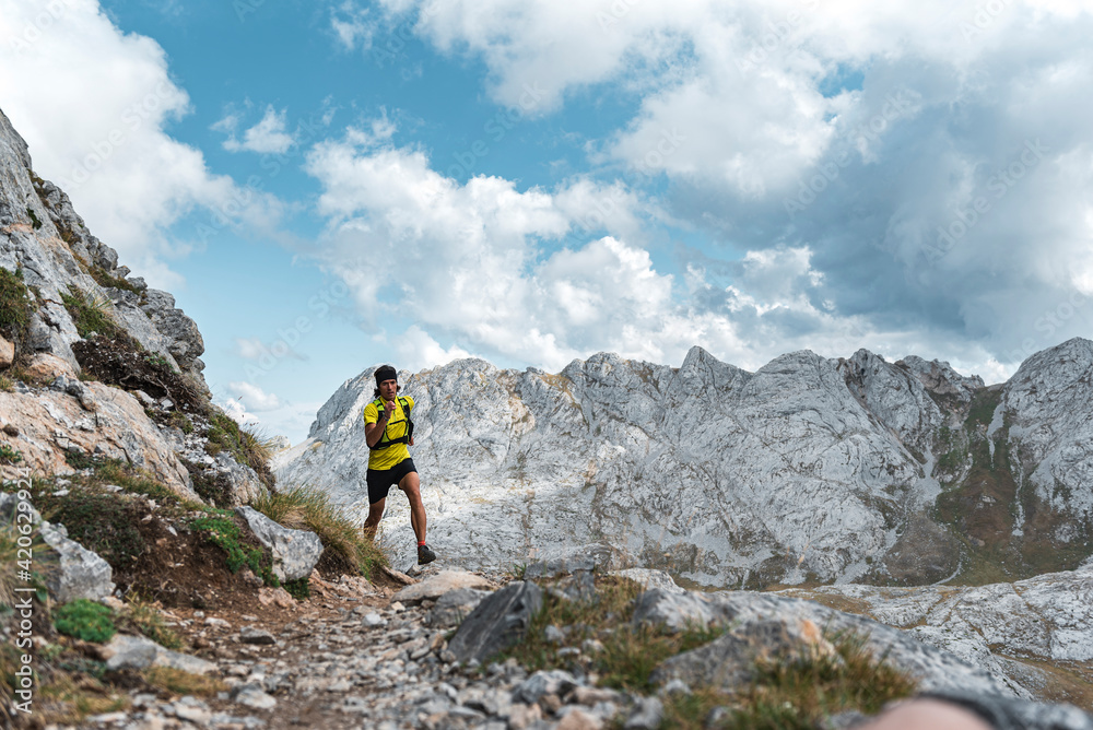Fit active middle aged man running a rocky mountain trail Fit active middle aged man running a rocky mountain trail
