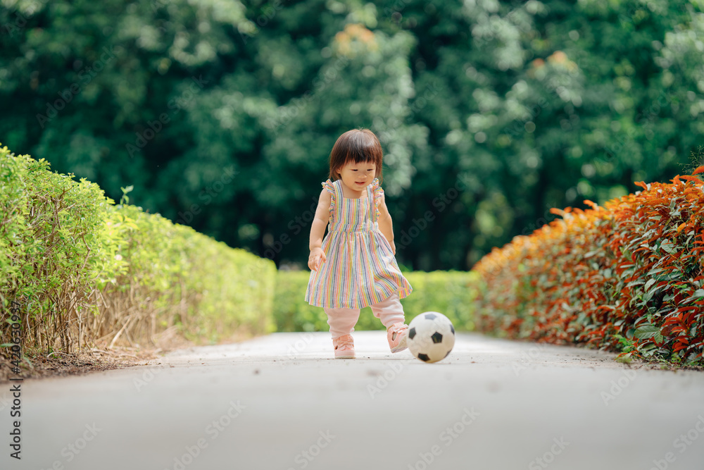 Little girl playing football outdoors Stock Photo | Adobe Stock