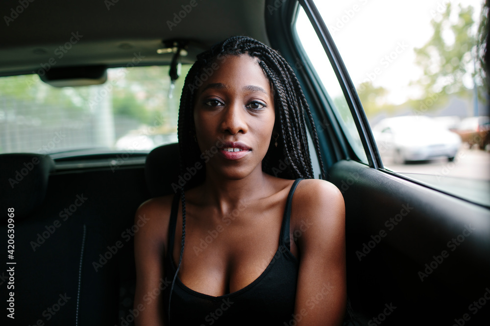 © Jimena Roquero/Stocksy - Young attractive woman in a car looking at camera