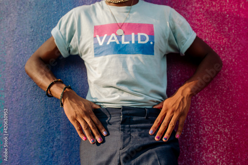 Torso of slender black male with hands on hips wearing VALID t-shirt