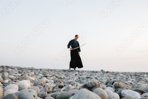 Blurred samurai on beach at sunset photo