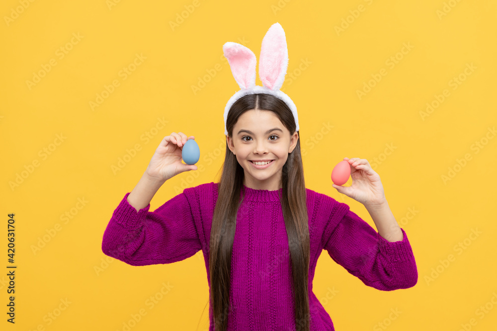 happy teen kid in bunny ears with painted eggs for easter, egg hunt