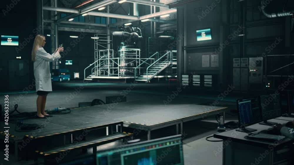 Female Engineer Uses Tablet Computer while Working in an Industial Facility at a Factory. Scientist uses Augmented Reality Software. Empty Space Left for Mock Up Template for VFX.
