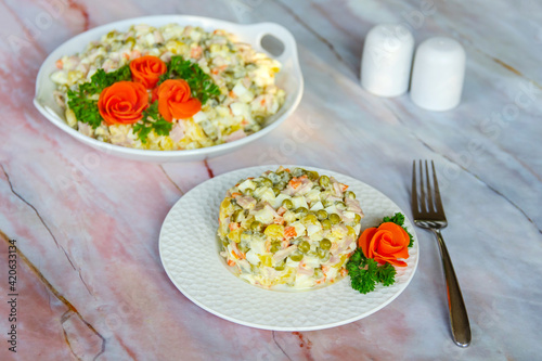 Traditional Russian festive salad Olivier (winter salad) on a white plate.
