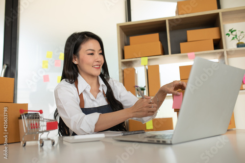Startup small business SME, Entrepreneur owner working at home office and checking online purchase shopping order to preparing pack product box. Selling online ,Online Shopping ideas concept
