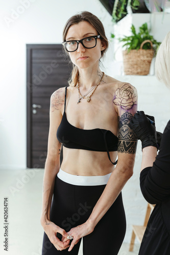 Tattoo artist and client in a tattoo studio.