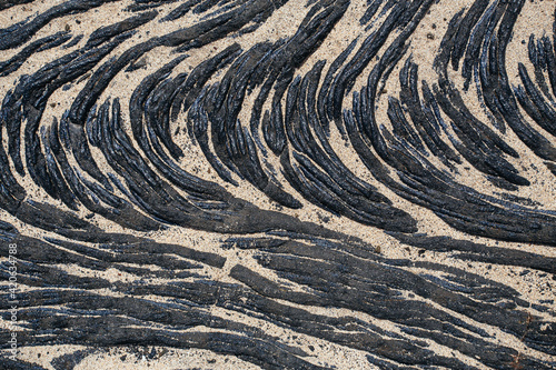 Lava flow partially covered by sand photo