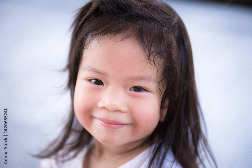 Closeup Asian little cute girl with a sweet smile. Child looking at the camera. Happy children. Adorable kids aged 3-4 years old. Closeup Asian little cute girl with a sweet smile. Child looking at the camera. Happy children. Adorable kids aged 3-4 years old.