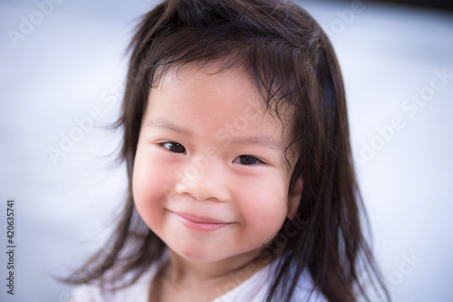 Closeup Asian little cute girl with a sweet smile. Child looking at the camera. Happy children. Adorable kids aged 3-4 years old.