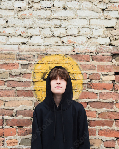 Teen Boy Against Brick Wall Looking Up photo