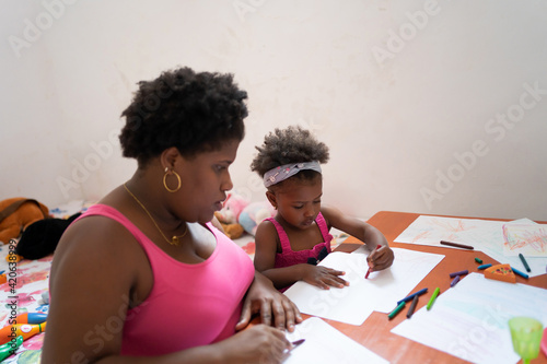 Daughter And Mother Drawing On The Table.