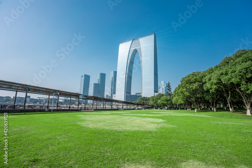 The modern skyline in Suzhou, with a green lawn in front. © Zimu