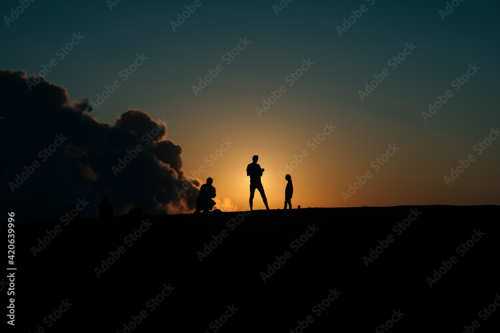 line of tourists watching sunset in the mountains line of tourists watching sunset in the mountains