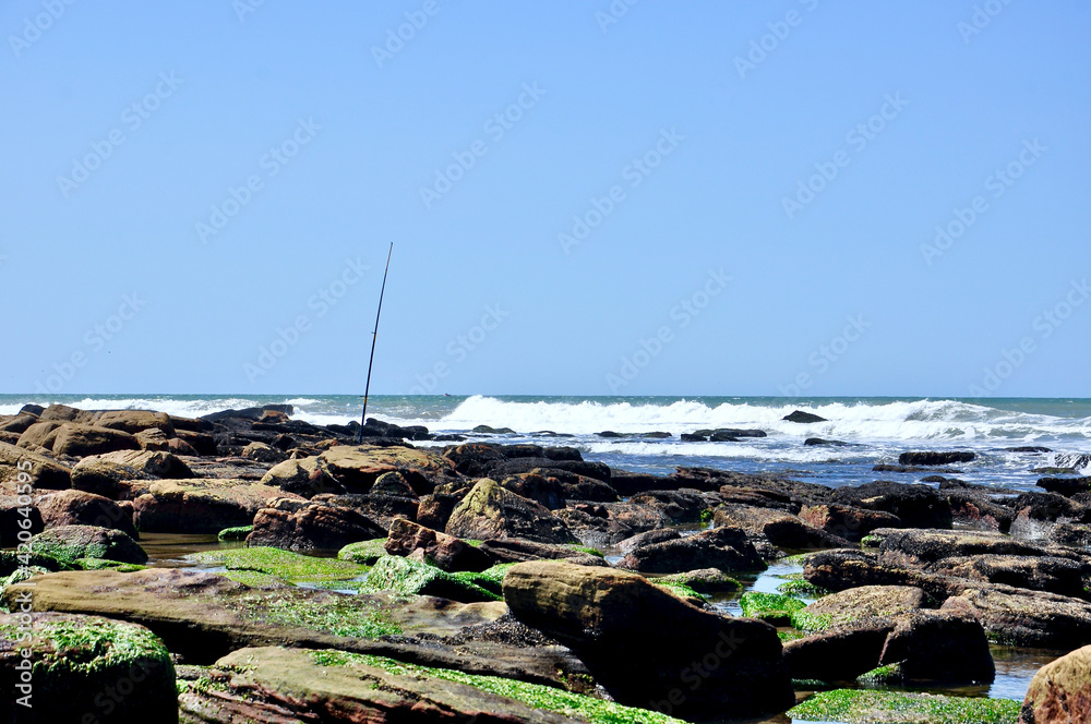 view of the sea from the coast with a fishing rod