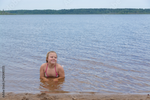 The girl frolics in the water on a hot sunny summer day and is happy. Kuvshinovo  Tver region  Russia.