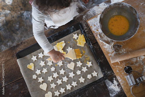 星型クッキーに卵を塗る、お菓子作りをする女の子