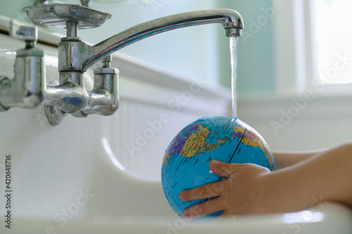 Child Washing Globe in Sink photo