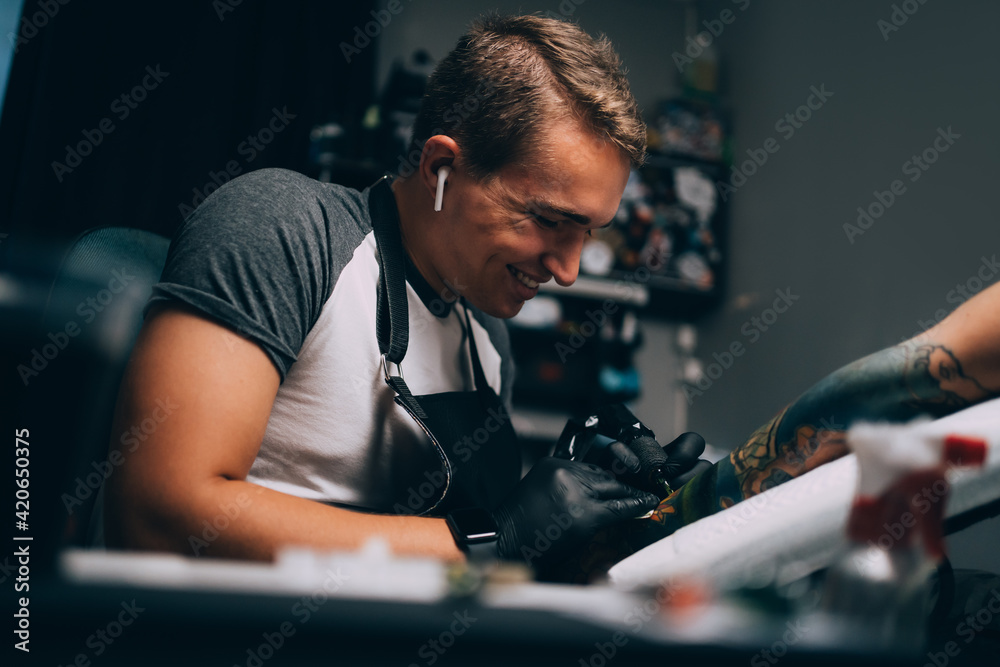 Tattooist working with client in salon Tattooist working with client in salon