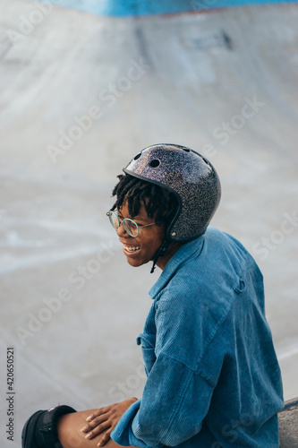 Portrait of a happy African American woman having a break in a skate park photo