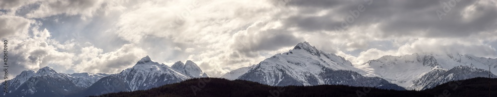 Panoramic Canadian Mountain Landscape View during a cloudy winter day. Taken in Tantalus Lookout near Squamish and Whistler, North of Vancouver, BC, Canada. Background Panorama