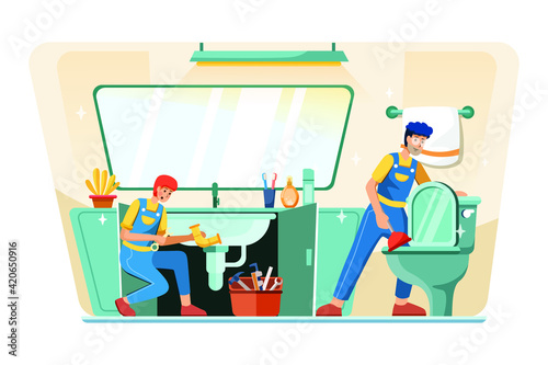 Young plumber is repairing the hand sink while the other plumber clearing the toilet.