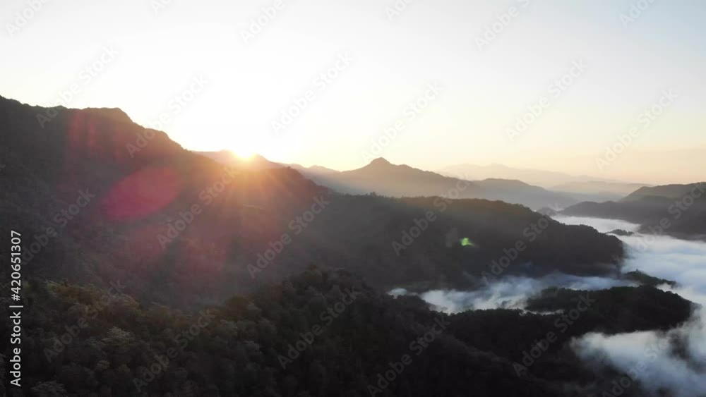 sun rise over a mountain valley covered with foggy mist and clouds, aerial shot sun rise over a mountain valley covered with foggy mist and clouds, aerial shot