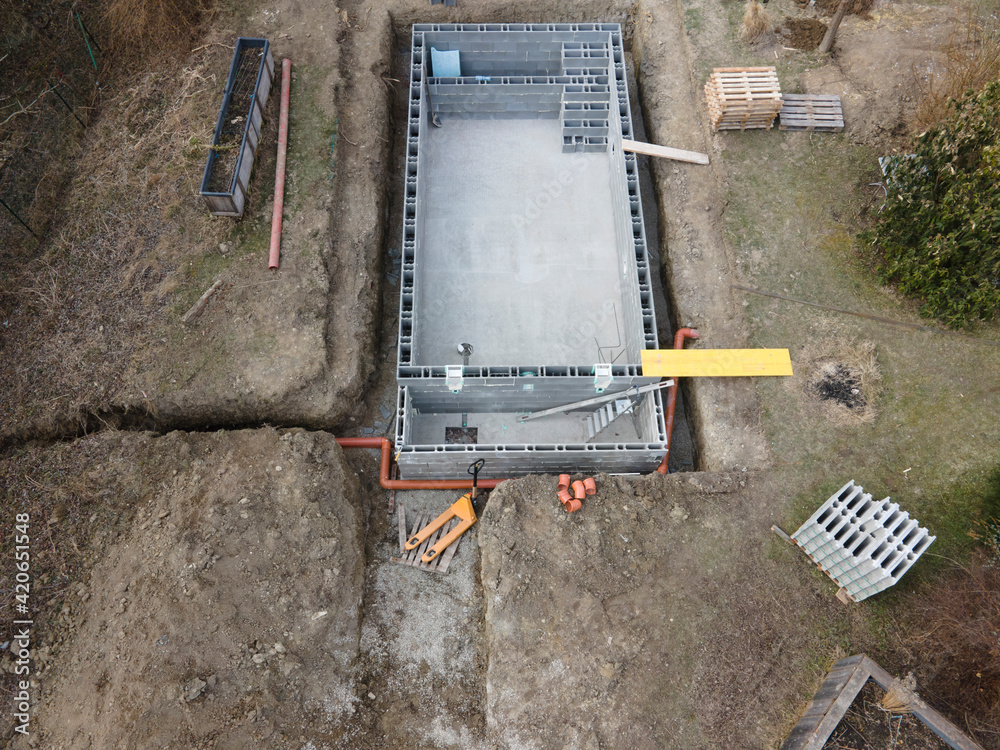 Drones aerial photo of a construction site of a pool, formwork concrete blocks already finished and bricked up with construction adhesive, steps already prepared and ready for concrete filling
