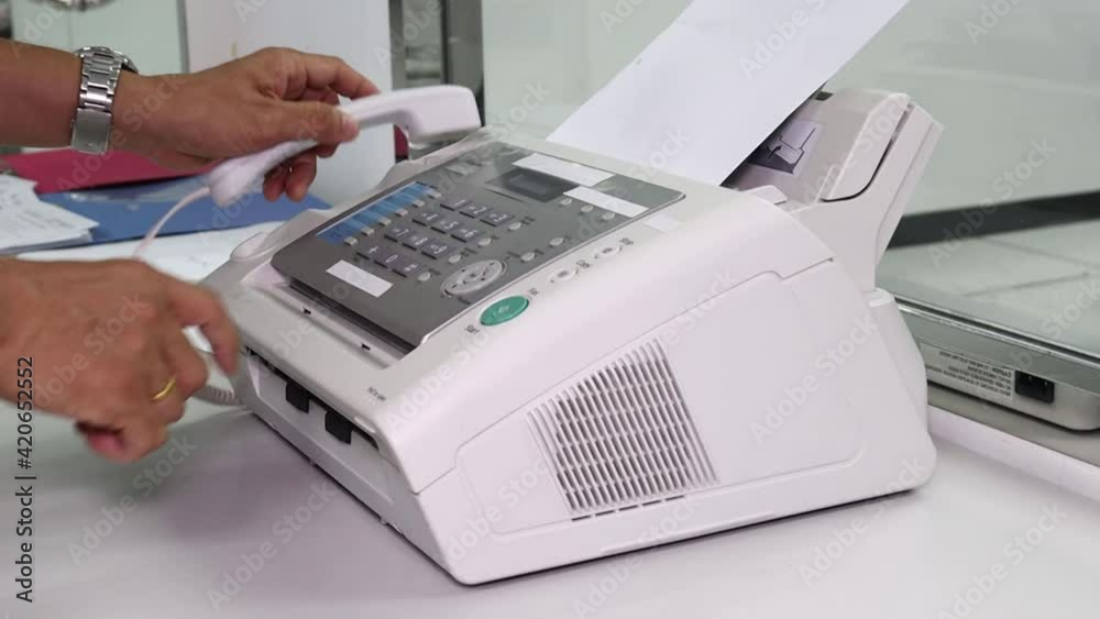 hand man are using a fax machine in the office, equipment for data transmission hand man are using a fax machine in the office, equipment for data transmission