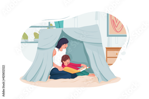 Nanny and little children reading book in tent at home