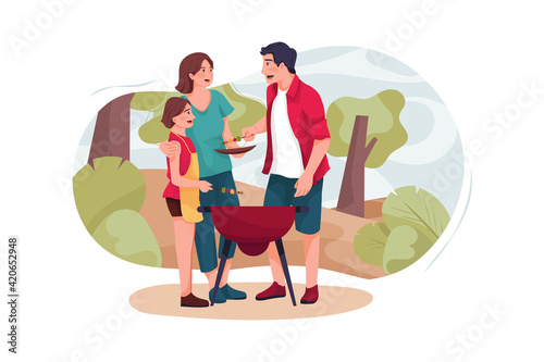 A small family has a barbecue in the forest.